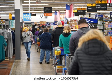 Cromwell, CT / USA - March 20, 2020: Perople wait in long lines for a chance at purchasing toilet paper or sanitizer at Walmart (focus on man with backwards cap)