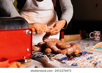 Crop anonymous woman in dirty apron making homemade sausages with stuffer machine in kitchen on table - Powered by Shutterstock