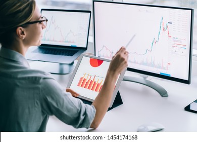 Crop back view of modern woman accounting statistical data while exploring charts on monitor of computer working at desk in office - Powered by Shutterstock