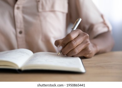 Crop close up of African American woman write take notes in notebook, engaged in time management at home. Biracial ethnic female make list or plan handwriting in paper notepad. Planner concept. - Powered by Shutterstock