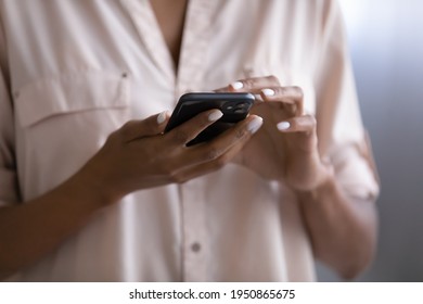 Crop close up of African American woman hold use modern smartphone gadget browse wireless internet on device. Biracial female text message on cellphone. Technology, communication concept. - Powered by Shutterstock