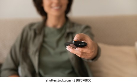 Crop Close Up Blurred Background Of Woman Hold Remote Controller Switch Turn Channels Watching Smart TV At Home. Female Relax Enjoy Programs Using High Quality Prepaid Satellite Television Service.