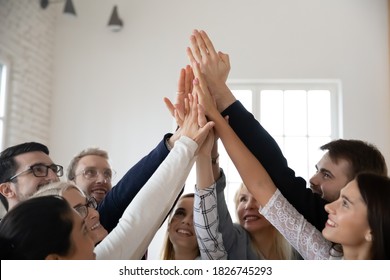Crop close up of diverse excited colleague give high five involved in motivational training in office. Overjoyed coworkers join hands take part in teambuilding activity, motivated for shared success. - Shutterstock ID 1826745293