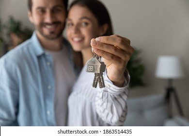 Crop close up of excited young Caucasian couple show keys to new shared home or dwelling. Happy man and woman spouses feel overjoyed moving relocating to own house. Rental, real estate concept. - Powered by Shutterstock