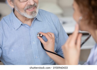 Crop close up of female doctor hold stethoscope listen to mature male patient heartbeat in private clinic. Woman nurse or GP use phonendoscope in hospital check mature man heart rate at consultation.