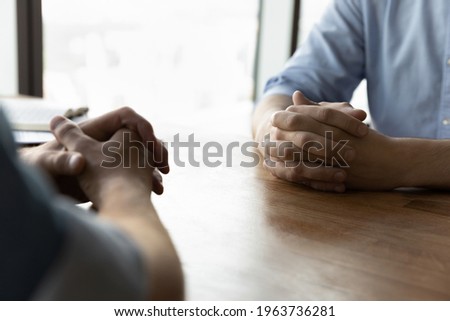Crop close up of male business partners sit at desk with hands clasped talk at meeting in office. Businessmen or opponents face each other at business negotiation at workplace. Rivalry concept. Stock photo © 