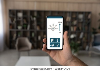 Crop Close Up Of Man Hold Use Modern Cellphone Gadgets With Smart Home Application On Screen. Male Client Or User Browse Smarthome System Control Panel On Smartphone Device. Technology Concept.