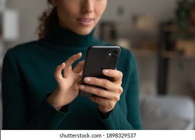 Crop close up of millennial female look at smartphone screen browse surf wireless internet on modern gadget. Young Caucasian woman hold use cellphone device text or message online on cell.