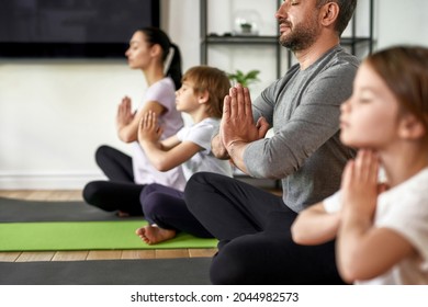 Crop Close Up Of Mindful Young Family With Children Sit Meditate With Mudra Hands Practice Yoga. Calm Caucasian Parents With Kids Have Meditation Session Breathe Fresh Air Relieve Negative Emotions.