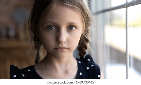 Crop close up portrait of serious sad little Caucasian girl look at camera, unhappy small child kid orphan feel lonely abandoned, outcast or loner miss parents, children drama, volunteer concept - Shutterstock ID 1789733465