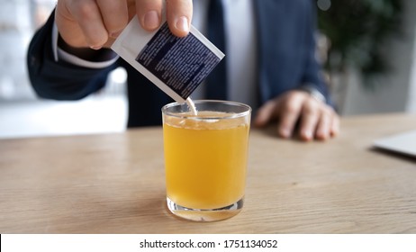 Crop close up of sick male employee pour dissolve powder have hot influenza tea in office, man worker take medication from sachet to relive flu or fever symptoms, high temperature, healthcare concept