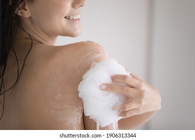 Crop Close Up Of Smiling Young Caucasian Woman Take Shower Rub Massage Body With Foam Gel Using Puff. Female Take Care Of Body Hygiene Wash In Bathroom With Natural Beauty Product. Skincare Concept.