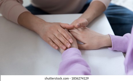 Crop close up top view of supportive Caucasian mother parent hold touch unhappy teen daughter hands show love and care. Mom parent caress comfort support sad unhappy teenage child. Parenthood concept. - Powered by Shutterstock