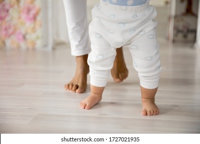 Crop Close Up Of Young Biracial Mom Hold Little Infant Toddler Learn Walking At Home, Small Baby Do Make First Steps With African American Mother Support And Care, Upbringing, Maternity Concept