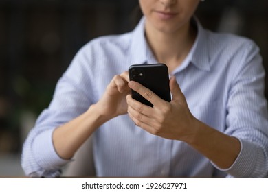 Crop close up of young Caucasian businesswoman use modern smartphone text or message with client partner online. Woman hold look at cellphone screen browse internet. Technology, communication concept.