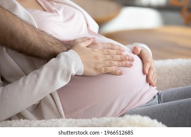 Crop Close Up Of Young Multiracial Parents Touch Wife Baby Bump Wait Expected For Kid Child To Be Born. Happy Diverse Couple Enjoy Easy Healthy Pregnancy Time Together At Home. Parenthood Concept.