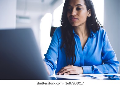 Crop Concentrated Young Black Female With Long Hair In Bright Shirt Working With Laptop Sitting At Office Desk In Day Time