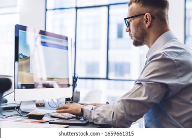 Crop contemporary office male employee in formal shirt and glasses sitting at desk and typing on computer working in modern light office. Online courses, studying via website on Pc computer - Shutterstock ID 1659661315
