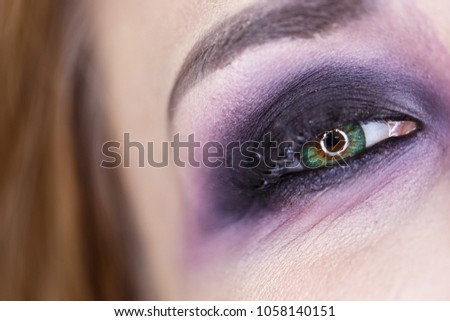 Crop of female eye with colorful make up. Beautiful fashion model with creative art makeup. Abstract colourful splash make-up. halloween festival