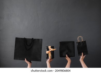 Crop of hand holding shopping bag or goodie bag for shopaholic online shopping background and black friday promotion - Shutterstock ID 2049806804