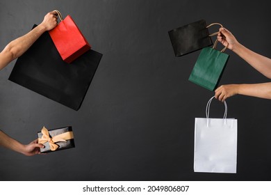 Crop of hand holding shopping bag or goodie bag for shopaholic or online shopping background - Shutterstock ID 2049806807