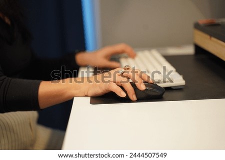 Crop image, Selective focus, Hands of Young woman typing on Keyboard and wireless mouse during working with desktop computer in modern office