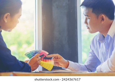 Crop image of worker checking print quality of media graphics proof print and color tone in printing industry. Selected focus