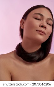 Crop Narrow Shot Of Naked Natural Young Asian Woman On Pink Studio Background Demonstrate Thick Healthy Hair, Salon Procedures. Beautiful Ethnic Female Model With Glowing Skin. Beauty Concept.