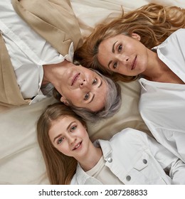 Crop Narrow Shot Portrait Of Happy Three Generations Of Caucasian Women Together On White Background. Top View Of Younger And Older Family Members, Girl Child With Mother And Grandmother.