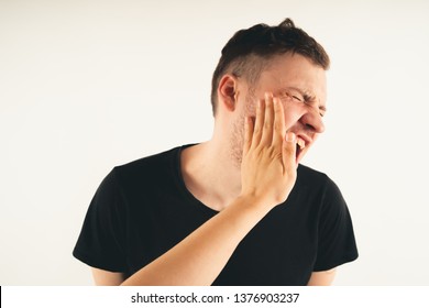 Crop person slapping scared man in face. Emotional male getting slapped in face while shouting with closed eyes in fear on white background