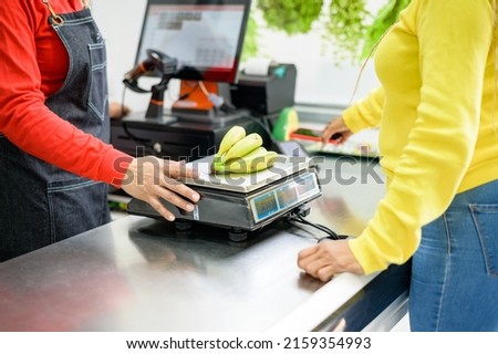 Crop seller weighing bananas for customer