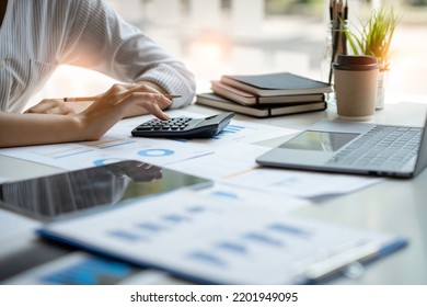 Crop Shot Of Business Woman Checks Her Work And Uses A Calculator To Calculate Her Annual Financial Statements. Turnover And Profit Balance Sheet Making Financial Records In Paper Audits.