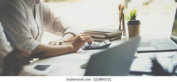 Crop Shot Of Business Woman Checks Her Work And Uses A Calculator To Calculate Her Annual Financial Statements. Turnover And Profit Balance Sheet Making Financial Records In Paper Audits.