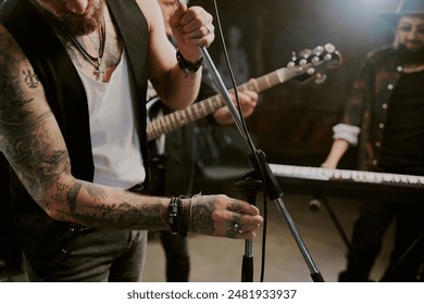 Crop shot of unrecognizable male rock vocalist getting ready for performance adjusting microphone stand - Powered by Shutterstock