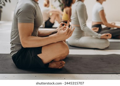 Crop of slender man meditating in lotus pose - Powered by Shutterstock