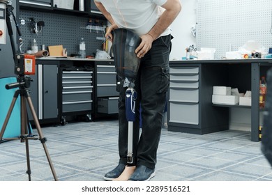 Crop unrecognizable craftsman adjusting and bending modern prosthetic leg at knee section at workbench in manufacturing factory - Powered by Shutterstock