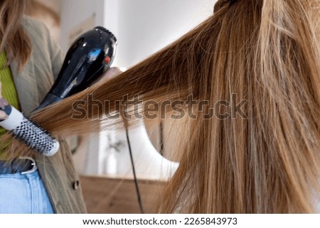 Foto Bild Abgeschnittene, nicht erkennbare Friseurin bei der Verwendung eines elektrischen Trimmers an den Haaren eines männlichen Kunden im Salon