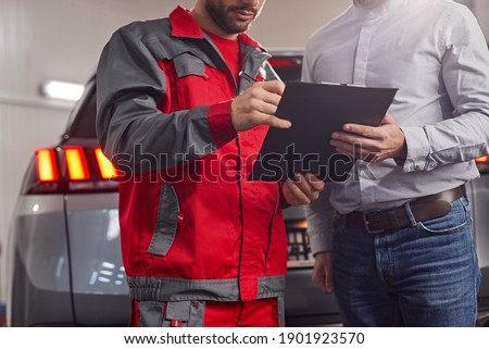 Similar – Image, Stock Photo Anonymous repairman examining car exhaust system in garage