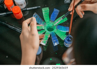 crop view female hand painting recycled plastic bottle waste using brush - Powered by Shutterstock