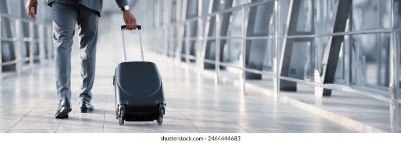 Cropped of African American Businessman At Airport Moving To Terminal Gate For Business Trip, Back View, Panorama With Copy Space - Powered by Shutterstock