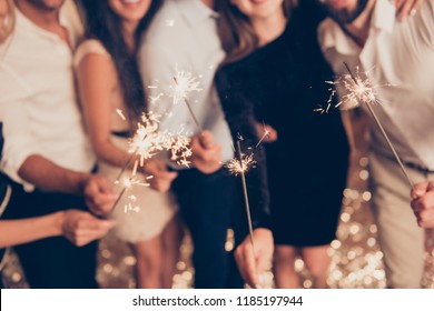 Cropped bengal fire sticks, sparkling, burning, elegant classy ladies and gentlemen's hands holding fire-sticks together, meeting, team, greetings, congrats - Powered by Shutterstock