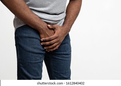 Cropped Of Black Man Holding His Groin Over White Background, Copy Space