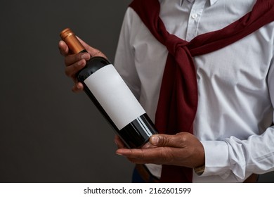 Cropped of black winemaker or sommelier holding wine bottle. Successful male entrepreneur or businessman. Viticulture and winemaking. Isolated on grey background. Studio shoot. Copy space - Shutterstock ID 2162601599