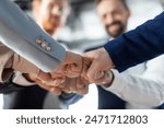 Cropped of a business teams hands clasped together in a fist bump, showcasing their camaraderie and unity. The image captures the essence of teamwork and collaboration in a professional setting.