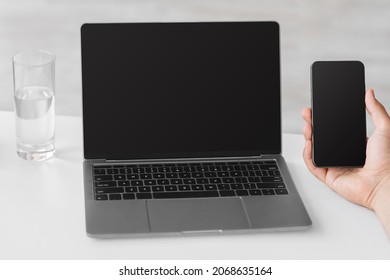 Cropped Caucasian Businessman With Smartphone And Laptop With Blank Screen On White Table At Workplace, Pov. Social Distance, New Normal, Modern Business, Work Remotely At Home Or Office, Mockup