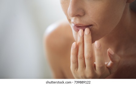 Cropped Caucasian woman putting balm on her lips.