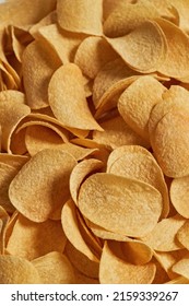 Cropped Close Up Background Texture Of Heap Of Tasty And Appetizing Potato Chips. Unhealthy Eating And Junk Food. Crunchy And Spicy High-calorie Snack For Leisure. Nobody