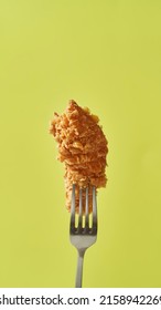 Cropped Close Up Of Fork With Baked Chicken Wing. Unhealthy Eating And Junk Food. Fried Cooked High-calorie Tasty And Appetizing Snack For Leisure. Isolated On Yellow Background In Studio. Copy Space