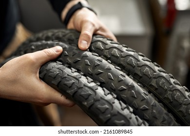 Cropped close up of girl hands holding new three bike tires. Bike service, repair and upgrade. Blurred professional female repairman or cycling sportswoman - Powered by Shutterstock