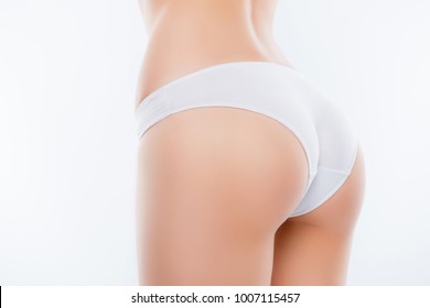 Cropped close up half-turned photo of ideal elastic flawless beautiful woman's ass wearing white underlinen underclothes isolated on background, having confidence with sanitary napkin, towel